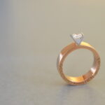 Prachtige solitair met logo van de goudsmid. Brede ring in rosé goud met een V-vormige zetting waarin een naturel briljant van 0.50ct gevat is