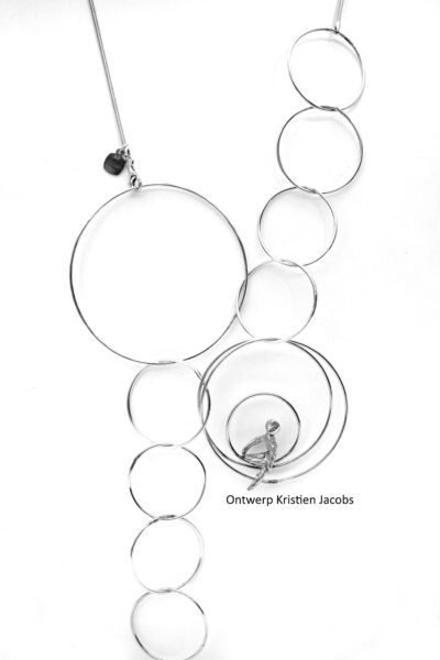 Halsketting in zilver met ringen van verschillende formaten. in één van de ringen zit een figuurtje te kijken